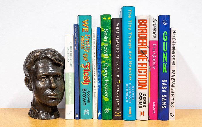 Bookshelf image of the 6 book spines accompanied by bronze bust of Dylan Thomas