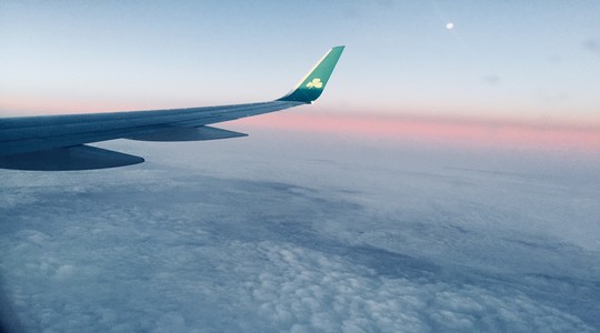 Aeroplane wing in flight as the sun sets.
